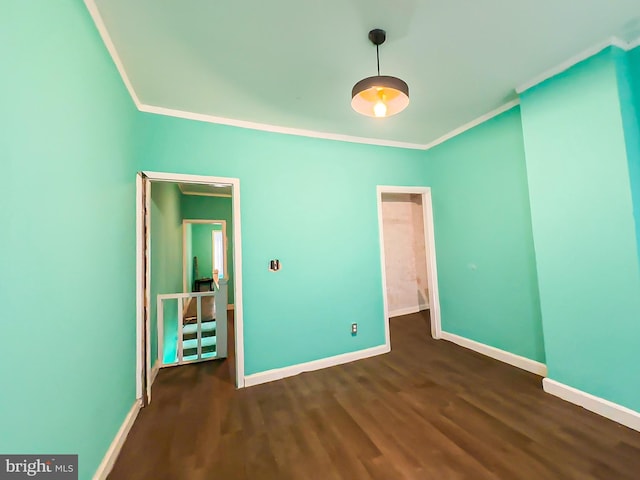 unfurnished bedroom with ornamental molding, dark wood-style flooring, and baseboards