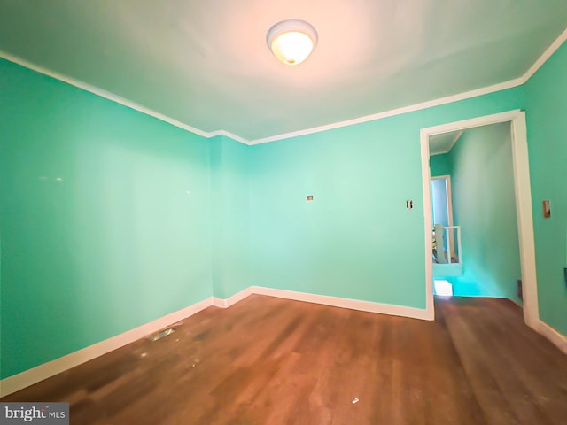 unfurnished room featuring baseboards, crown molding, and wood finished floors