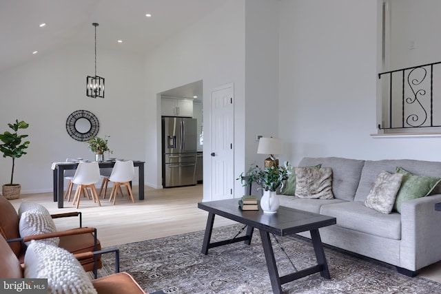 living area featuring recessed lighting, an inviting chandelier, wood finished floors, high vaulted ceiling, and baseboards