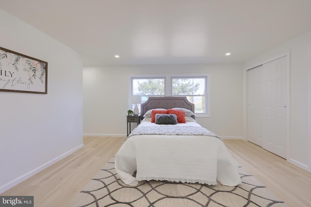 bedroom featuring a closet, recessed lighting, light wood-style flooring, and baseboards