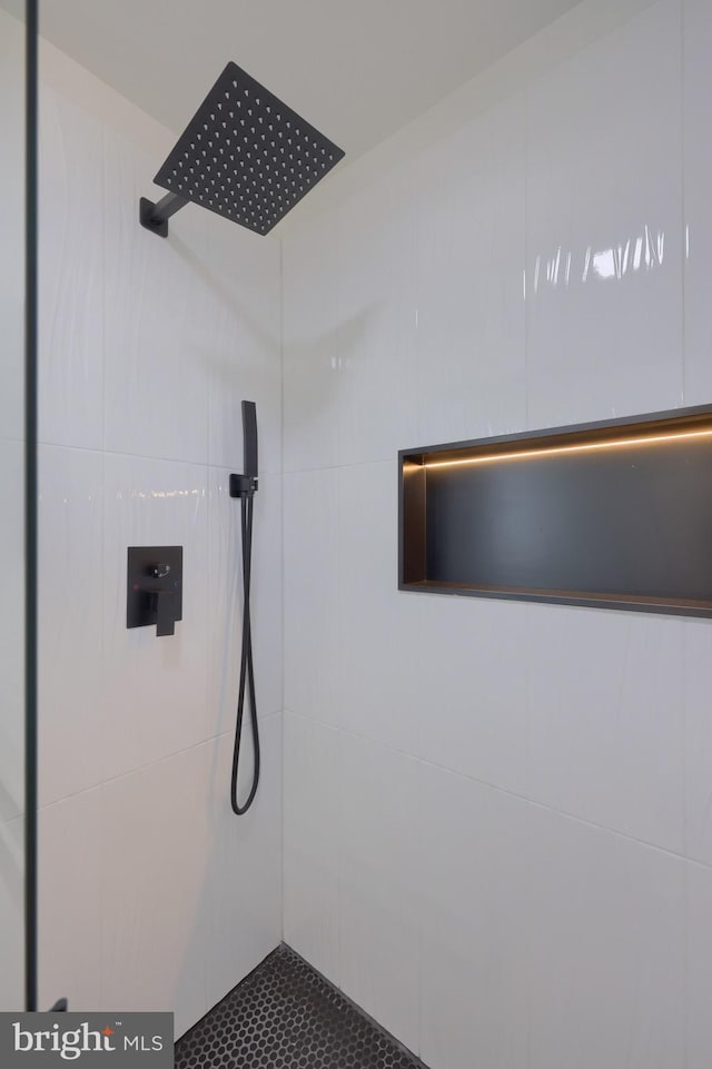 interior details with a tile shower