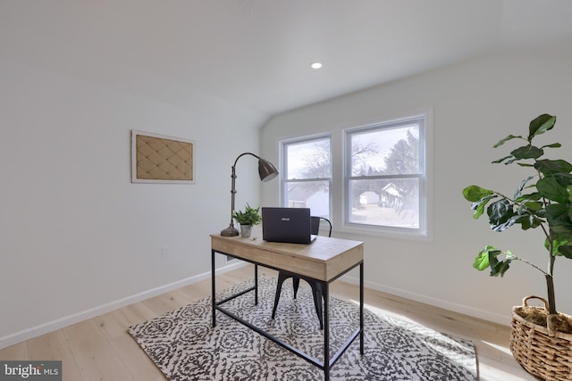 office featuring light wood-type flooring, baseboards, and lofted ceiling