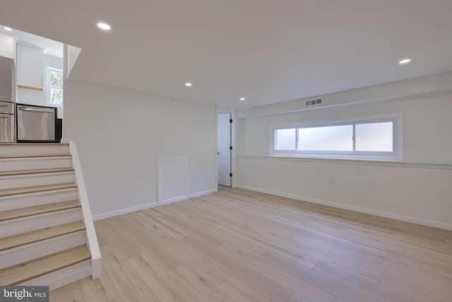 unfurnished room with stairs, light wood finished floors, visible vents, and recessed lighting