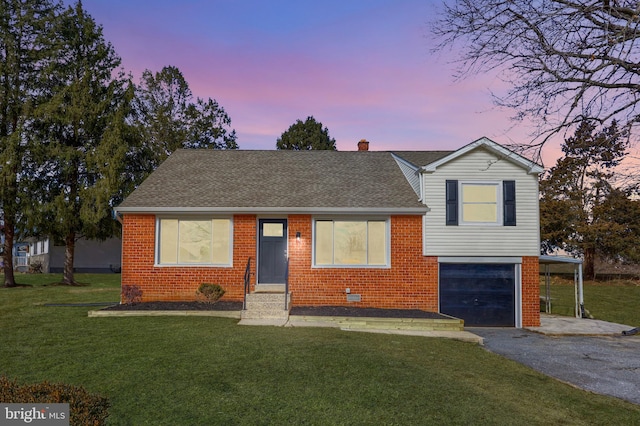 tri-level home with aphalt driveway, brick siding, and roof with shingles