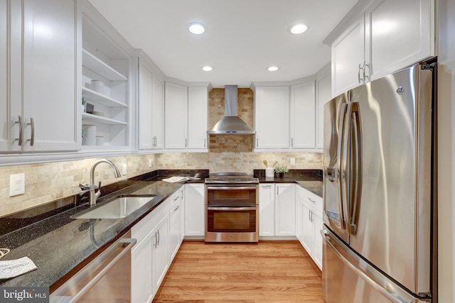 kitchen featuring open shelves, a sink, white cabinetry, appliances with stainless steel finishes, and wall chimney exhaust hood