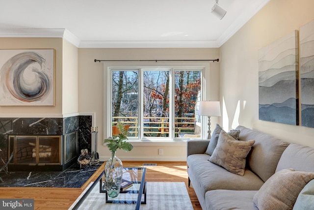 living area with a fireplace, wood finished floors, visible vents, and crown molding