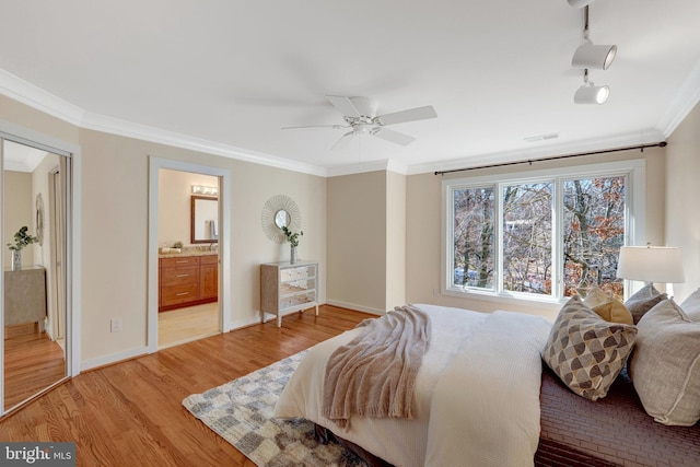 bedroom with light wood-style floors, visible vents, ornamental molding, and baseboards