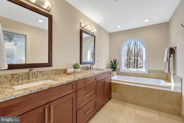 full bathroom featuring double vanity, a sink, a bath, and recessed lighting