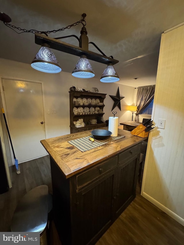 kitchen with dark wood-type flooring, wood counters, and kitchen peninsula