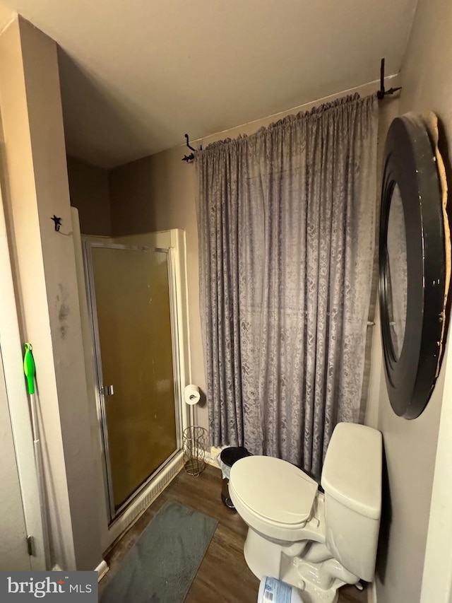 bathroom featuring hardwood / wood-style flooring, toilet, and walk in shower