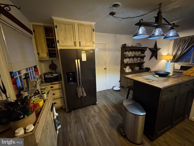 kitchen with dark wood-type flooring, light brown cabinetry, wooden counters, decorative light fixtures, and stainless steel fridge