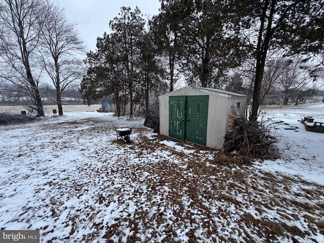 yard layered in snow with a storage unit