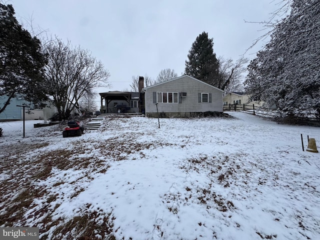 view of snow covered back of property