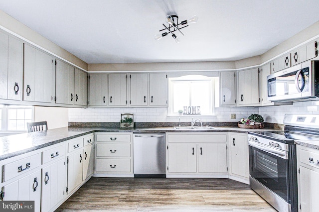 kitchen with appliances with stainless steel finishes, sink, backsplash, and a wealth of natural light