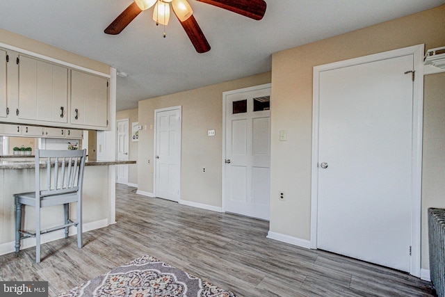 kitchen with white cabinetry, ceiling fan, and light hardwood / wood-style floors