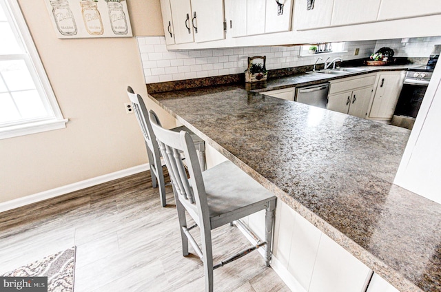 kitchen with oven, sink, stainless steel dishwasher, and tasteful backsplash