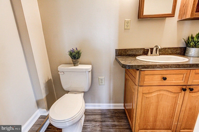 bathroom featuring toilet, wood-type flooring, and vanity