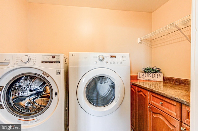 washroom featuring washer and dryer and cabinets