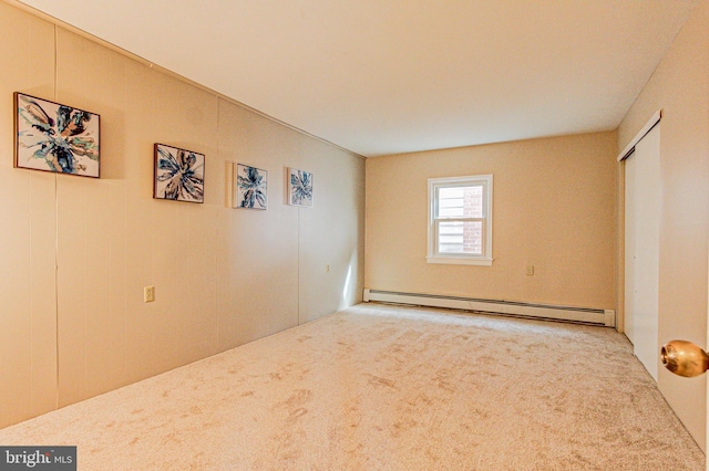 carpeted spare room featuring baseboard heating