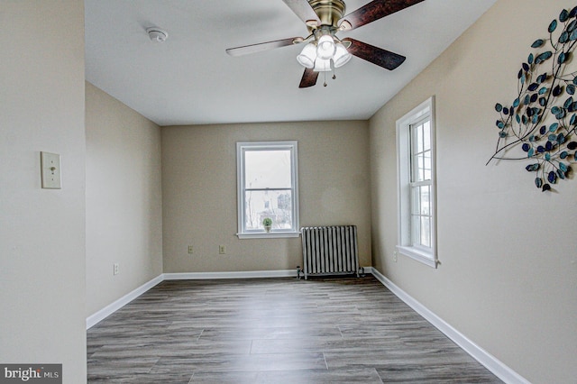 spare room with light hardwood / wood-style flooring, ceiling fan, and radiator