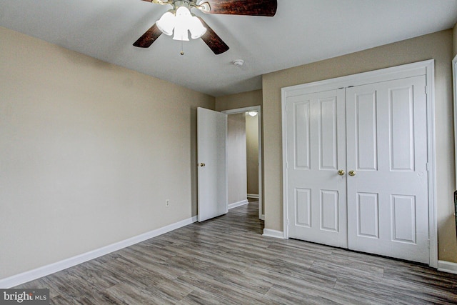 unfurnished bedroom with light hardwood / wood-style floors, a closet, and ceiling fan