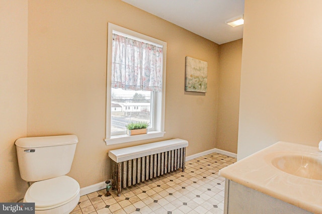 bathroom featuring toilet, vanity, and radiator heating unit