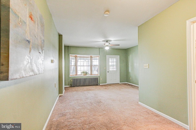 interior space with ceiling fan, carpet floors, and radiator heating unit