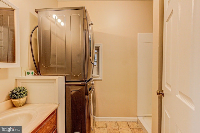 bathroom with stacked washing maching and dryer and vanity