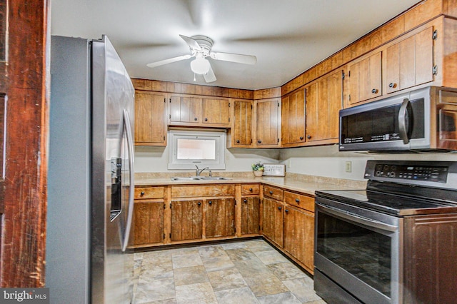 kitchen featuring ceiling fan, stainless steel appliances, and sink