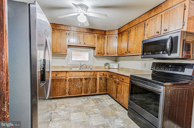 kitchen featuring ceiling fan, stainless steel appliances, and sink