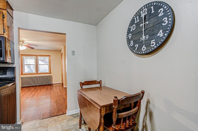 dining area featuring ceiling fan and radiator