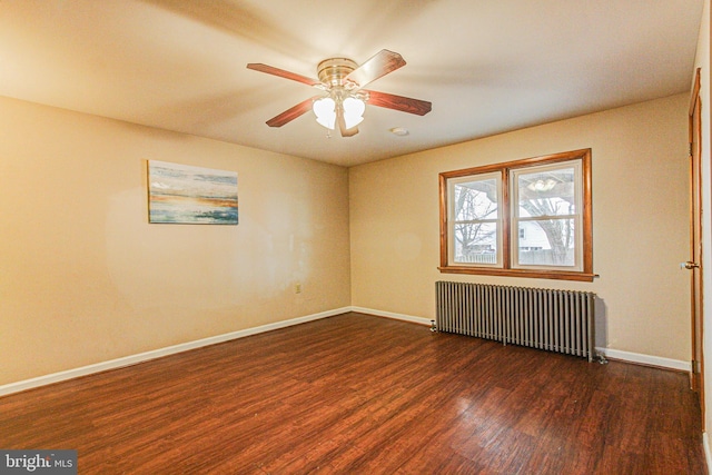 empty room with ceiling fan, dark hardwood / wood-style floors, and radiator heating unit