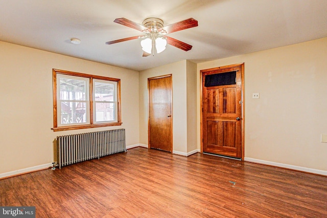 unfurnished bedroom with ceiling fan, hardwood / wood-style floors, and radiator heating unit