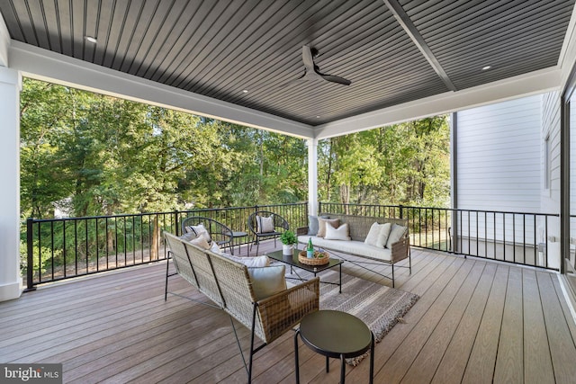 wooden deck with an outdoor living space and ceiling fan