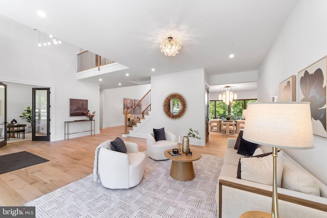 living room with an inviting chandelier and light wood-type flooring