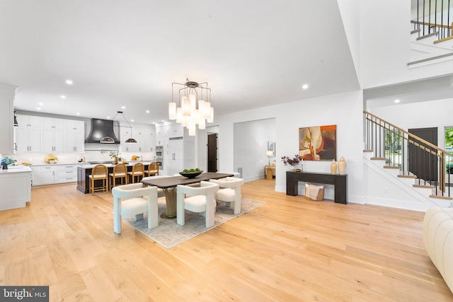 dining room with light hardwood / wood-style floors and a notable chandelier