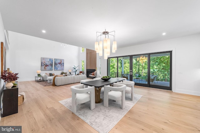 dining room featuring a notable chandelier, french doors, and light wood-type flooring