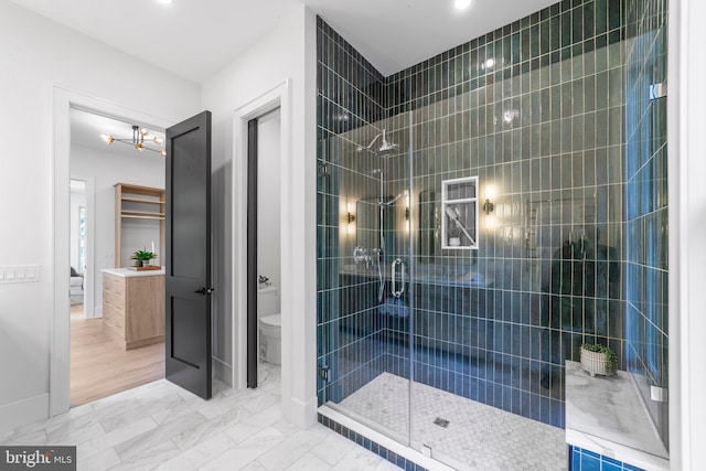 bathroom with a shower with shower door and toilet