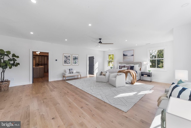 bedroom with multiple windows, ensuite bath, and light hardwood / wood-style floors