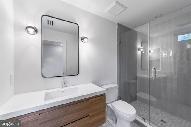 bathroom with vanity, toilet, and a shower with door