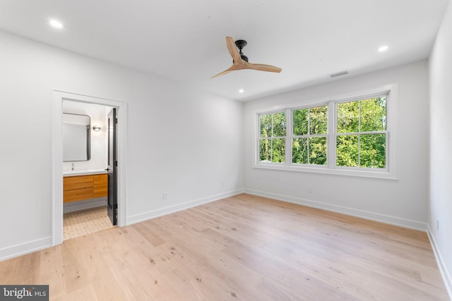 unfurnished bedroom with ensuite bath, ceiling fan, and light wood-type flooring