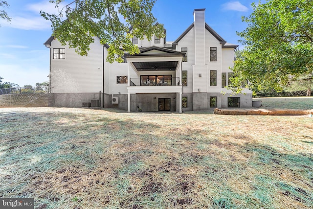 back of house featuring central AC and a lawn