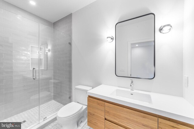 bathroom with an enclosed shower, vanity, and toilet