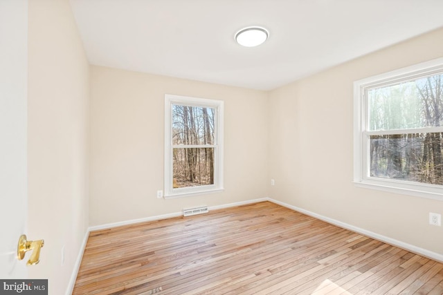 empty room featuring plenty of natural light and light hardwood / wood-style flooring