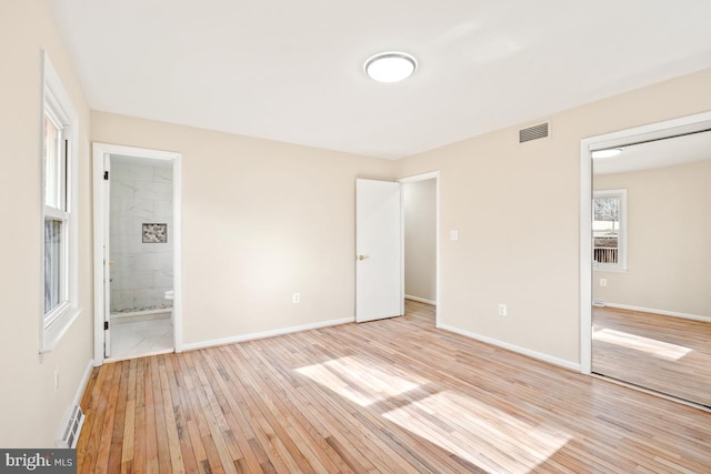 unfurnished bedroom featuring light hardwood / wood-style floors and connected bathroom