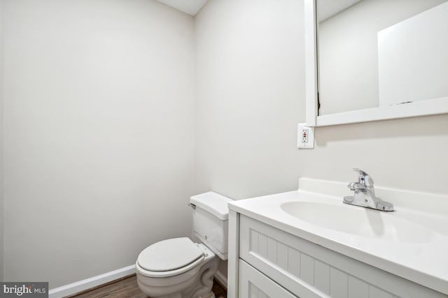 bathroom with wood-type flooring, vanity, and toilet