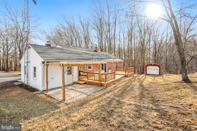 exterior space featuring a deck, a garage, and an outbuilding