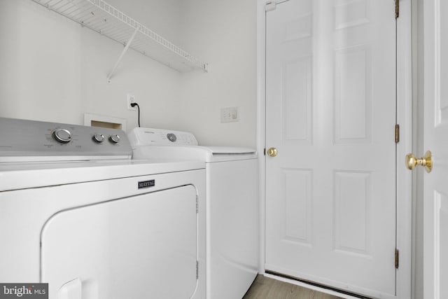 laundry room with independent washer and dryer and light wood-type flooring