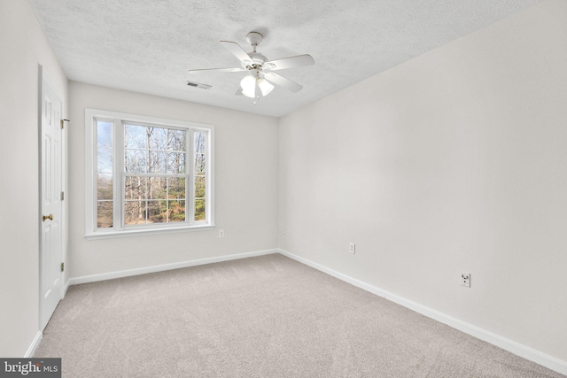 carpeted empty room featuring a textured ceiling and ceiling fan