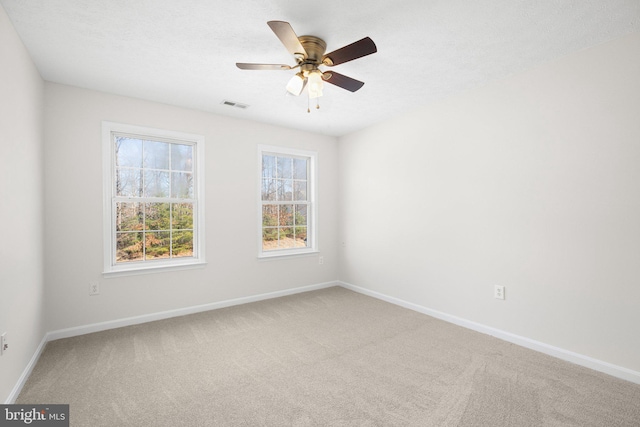 carpeted spare room featuring ceiling fan and a textured ceiling